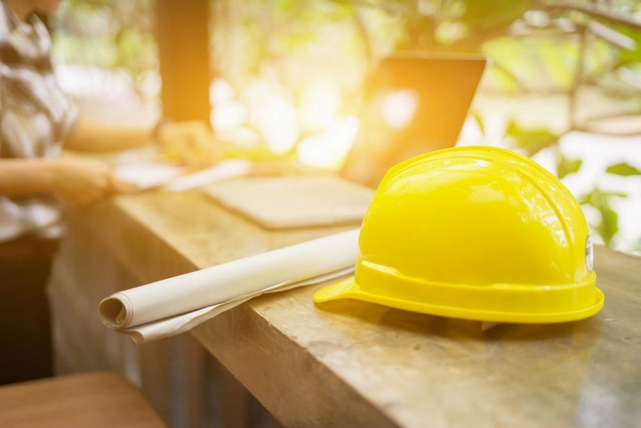 un elmetto giallo posato su un piano di legno in un cantiere